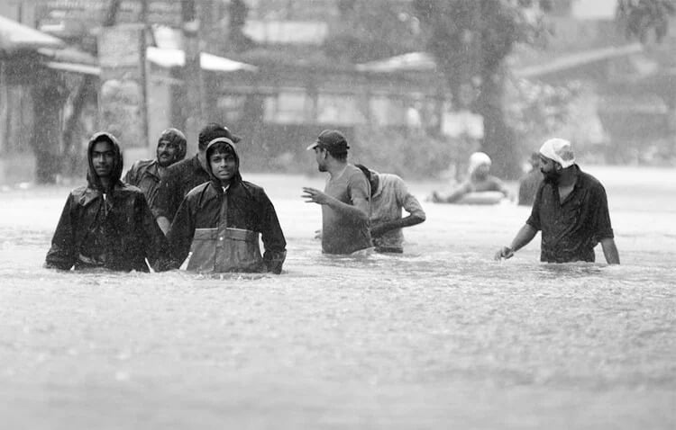 A group of men standing in an area flooded with water